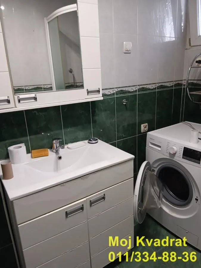 Bathroom with a sink, mirror and washing machine.