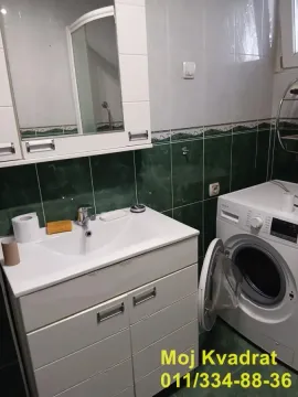 Bathroom with a sink, mirror and washing machine. - image 14