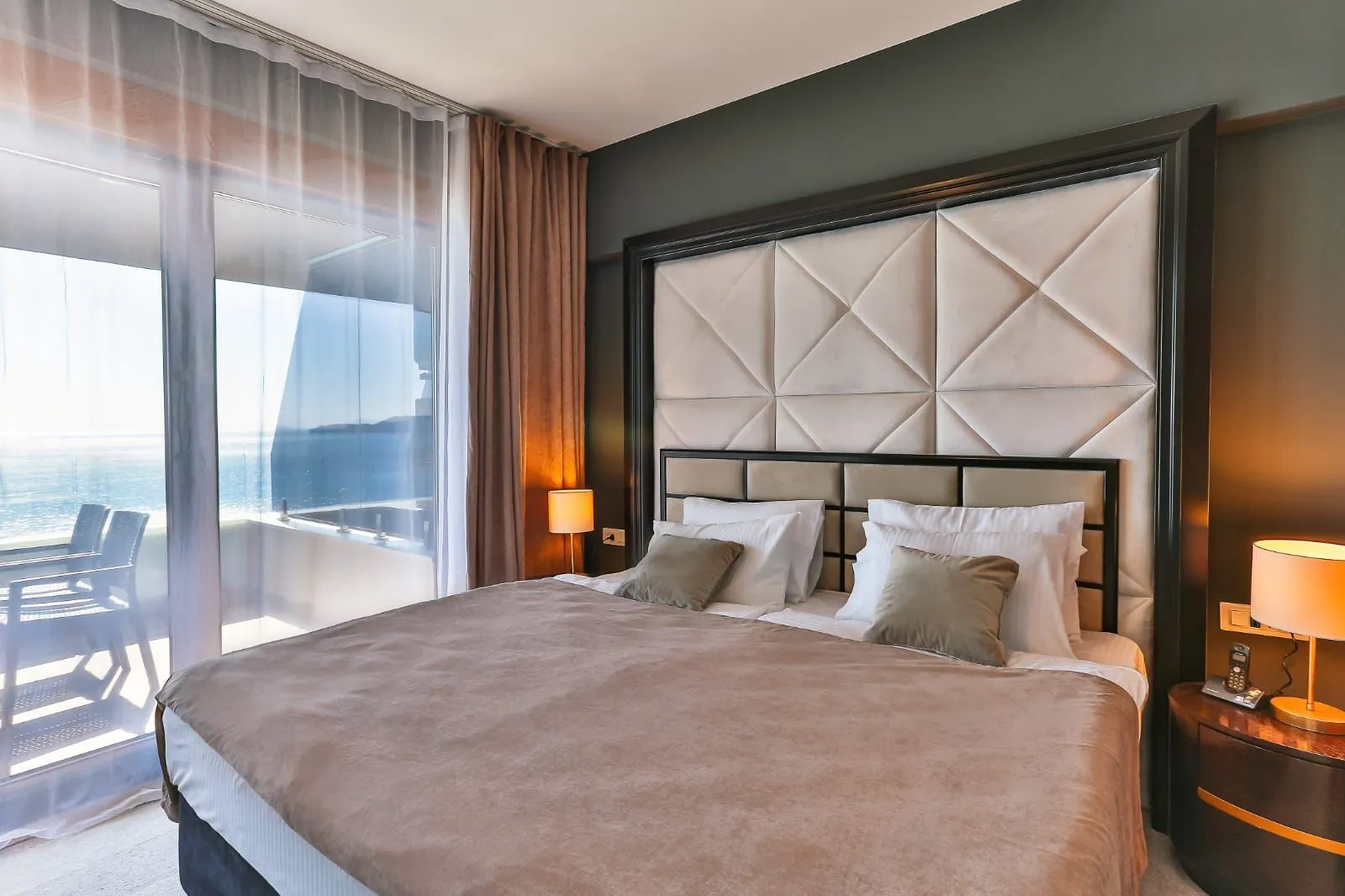 Modern bedroom with a double bed and access to a sea view terrace.