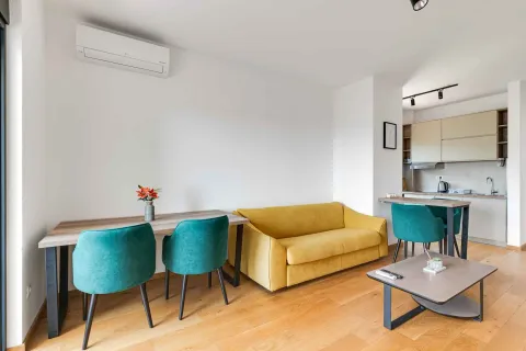 Living room with a sofa and dining table, overlooking the kitchen. - image 9