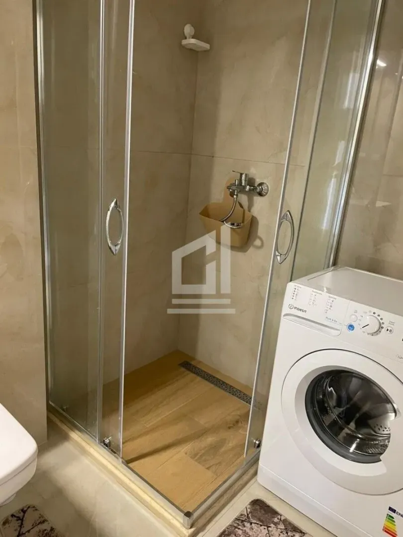 Bathroom with a shower cabin and washing machine.