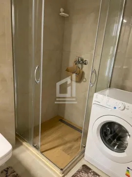 Bathroom with a shower cabin and washing machine. - image 7