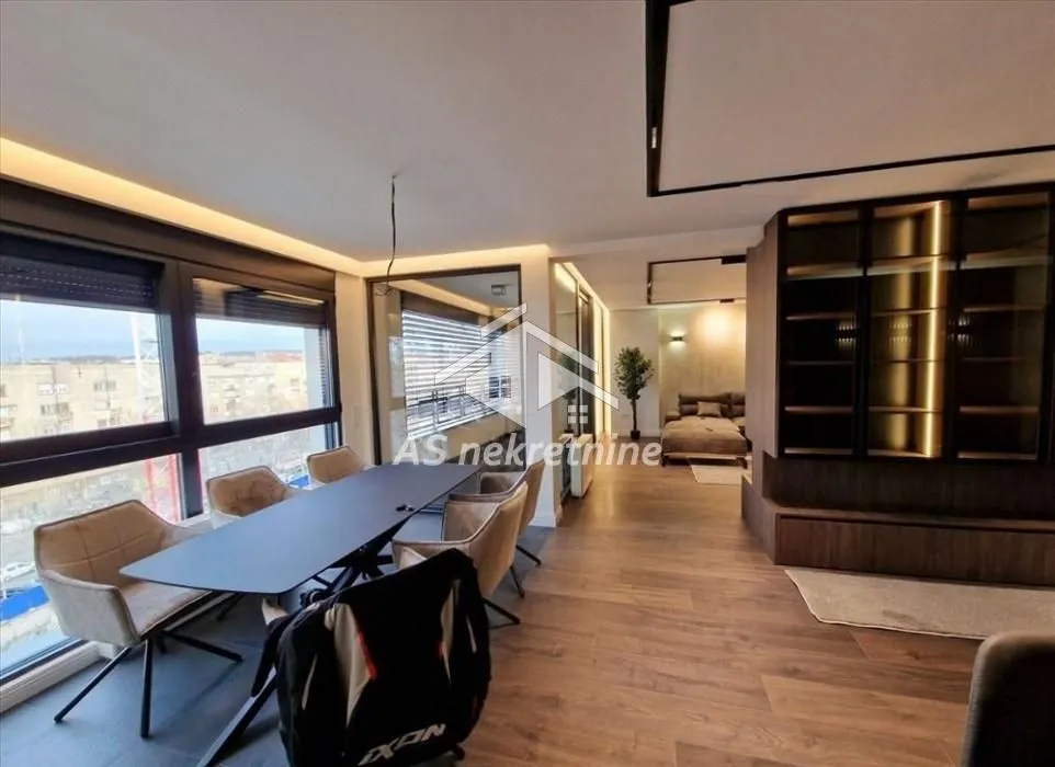 Modern living room with dining area and large windows.