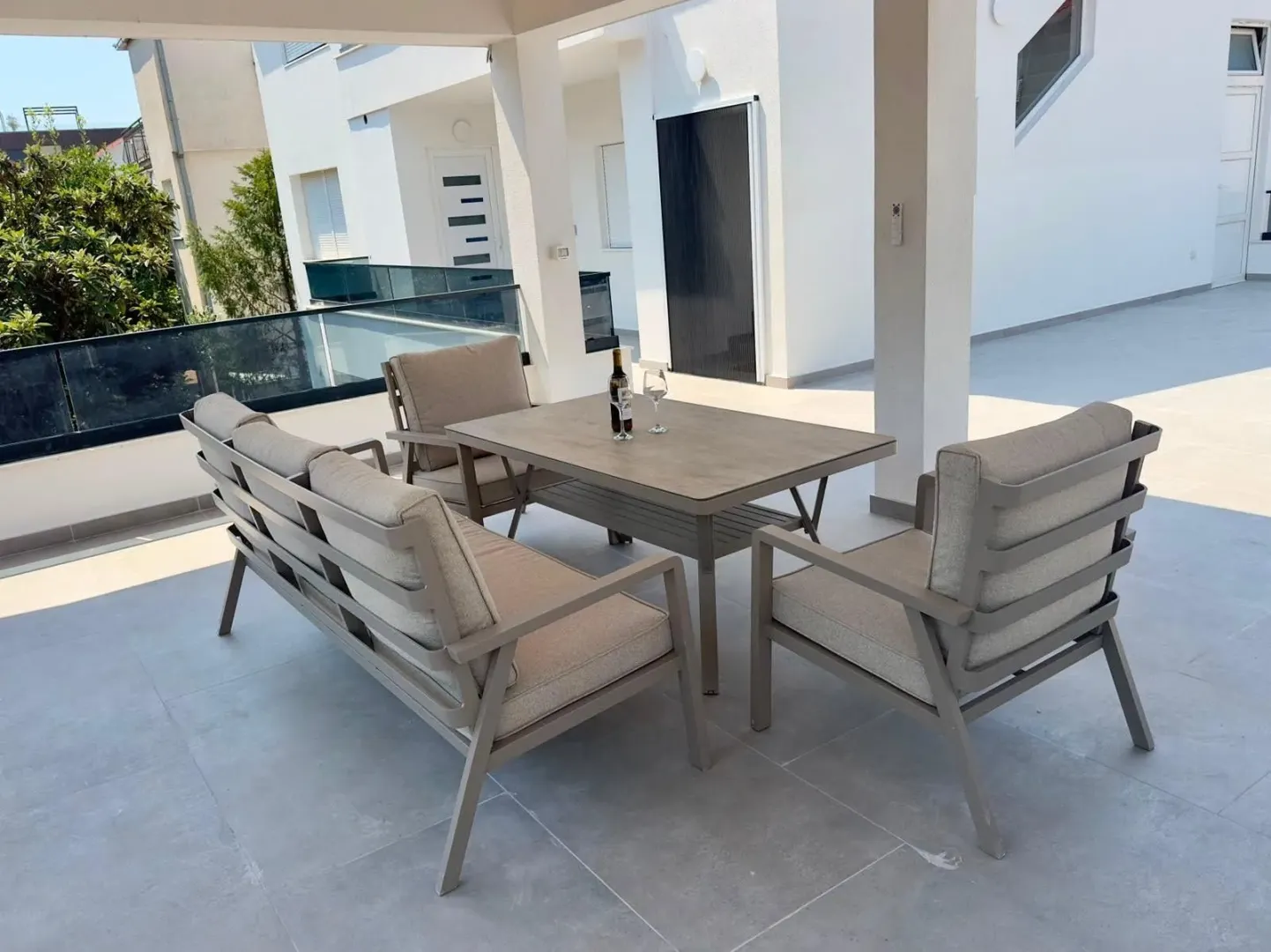 Spacious covered terrace with seating set and table.
