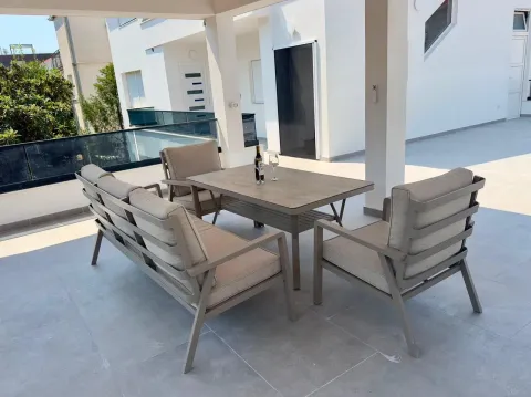 Spacious covered terrace with seating set and table. - image 16