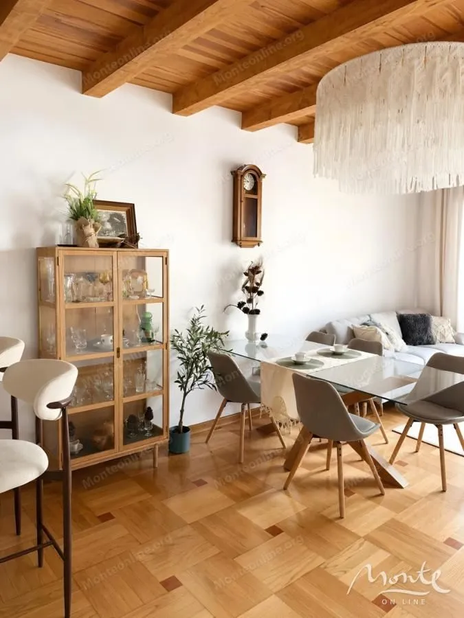 Living room with a dining area, wooden ceiling, and parquet flooring.