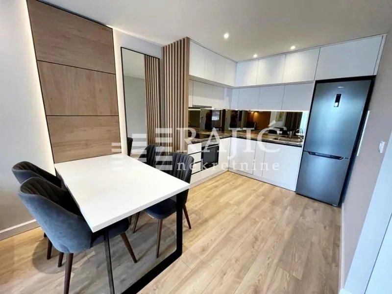 Modern kitchen with dining area and built-in appliances.