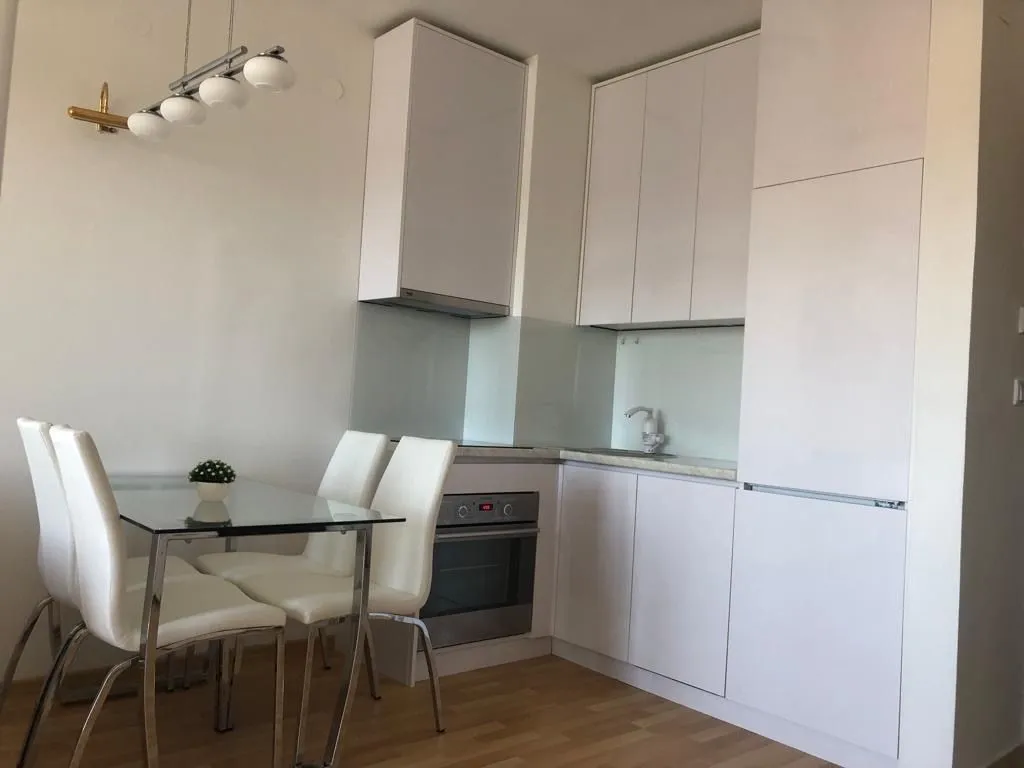 Modern white kitchen with a dining table.