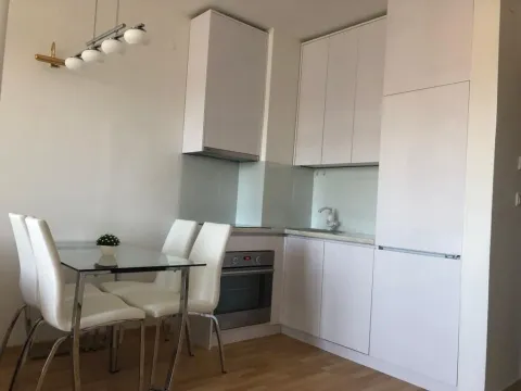 Modern white kitchen with a dining table. - image 2