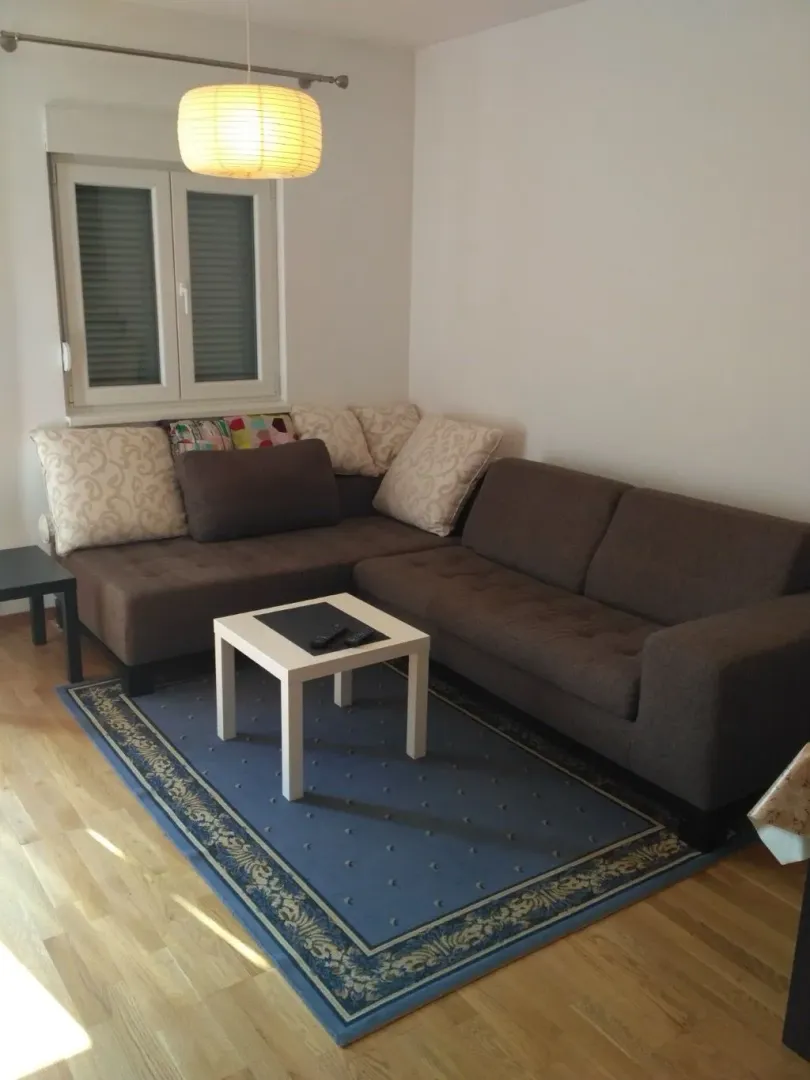 Living room with a sectional sofa, coffee table and rug.