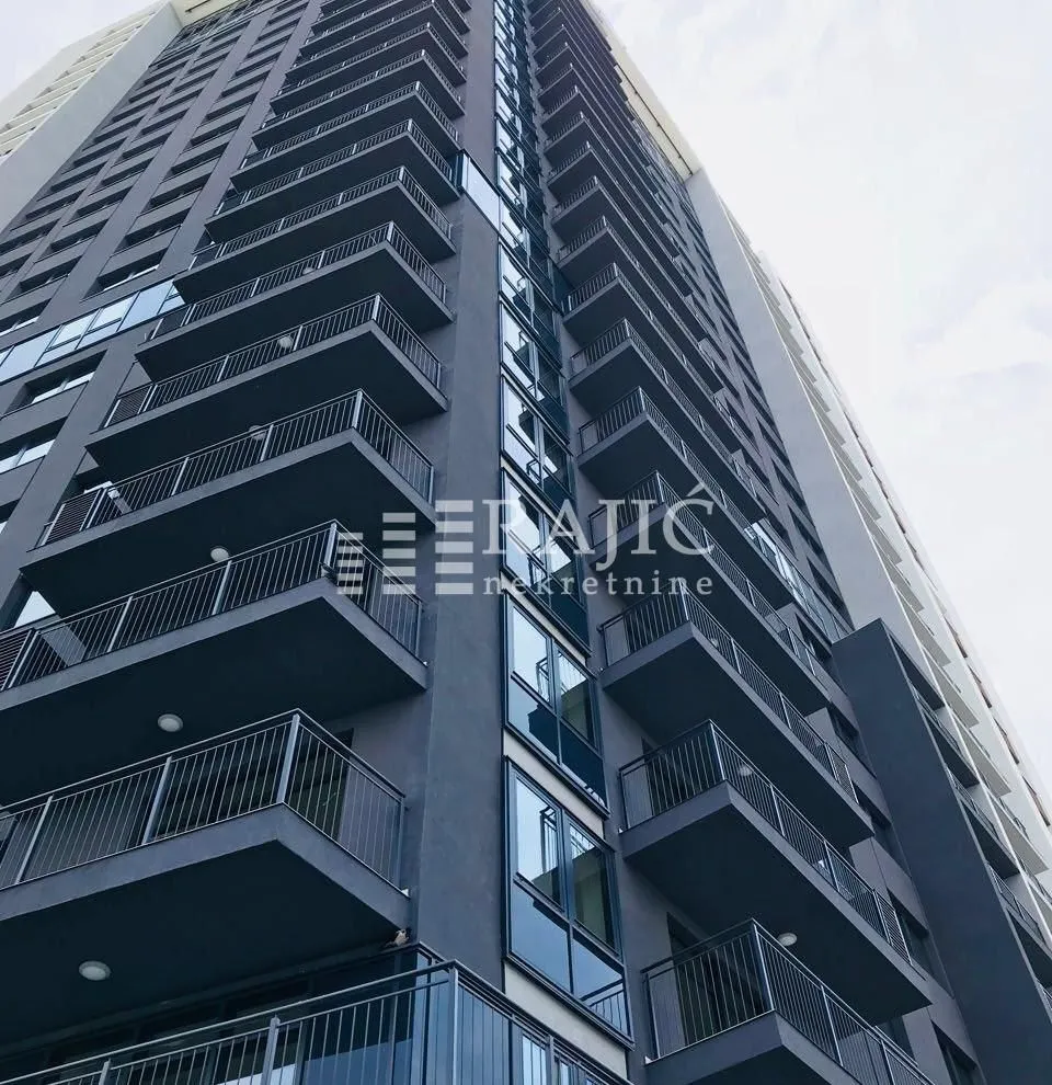 Exterior view of a modern multi-story residential building with balconies.