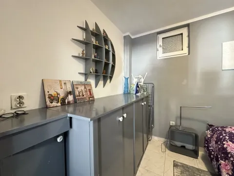 Small bedroom with grey furniture and a decorative wall shelf. - image 11