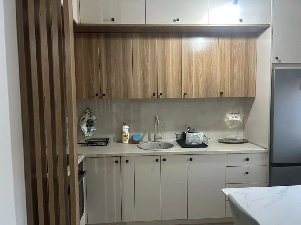 Modern kitchen with wooden cabinetry and built-in appliances.
