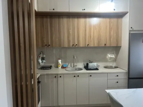 Modern kitchen with wooden cabinetry and built-in appliances. - image 4