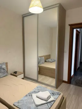 Namještena spavaća soba sa velikim ugradnim ormarom i bračnim krevetom. - image 10