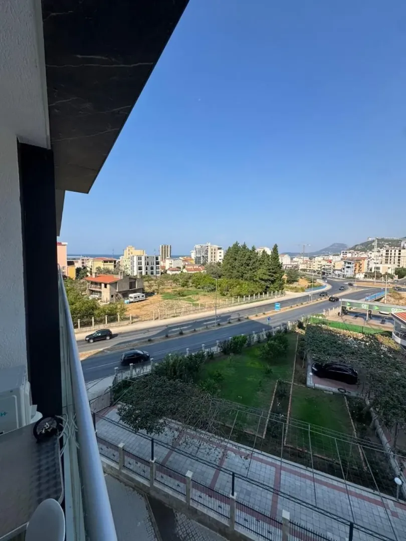 Pogled sa balkona na okolne zgrade i saobraćajnicu.