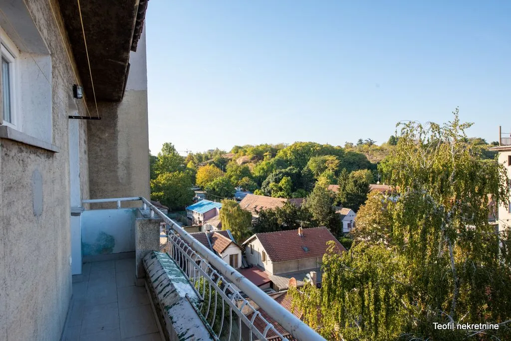 Pogled sa balkona na okolne kuće i zelenilo.