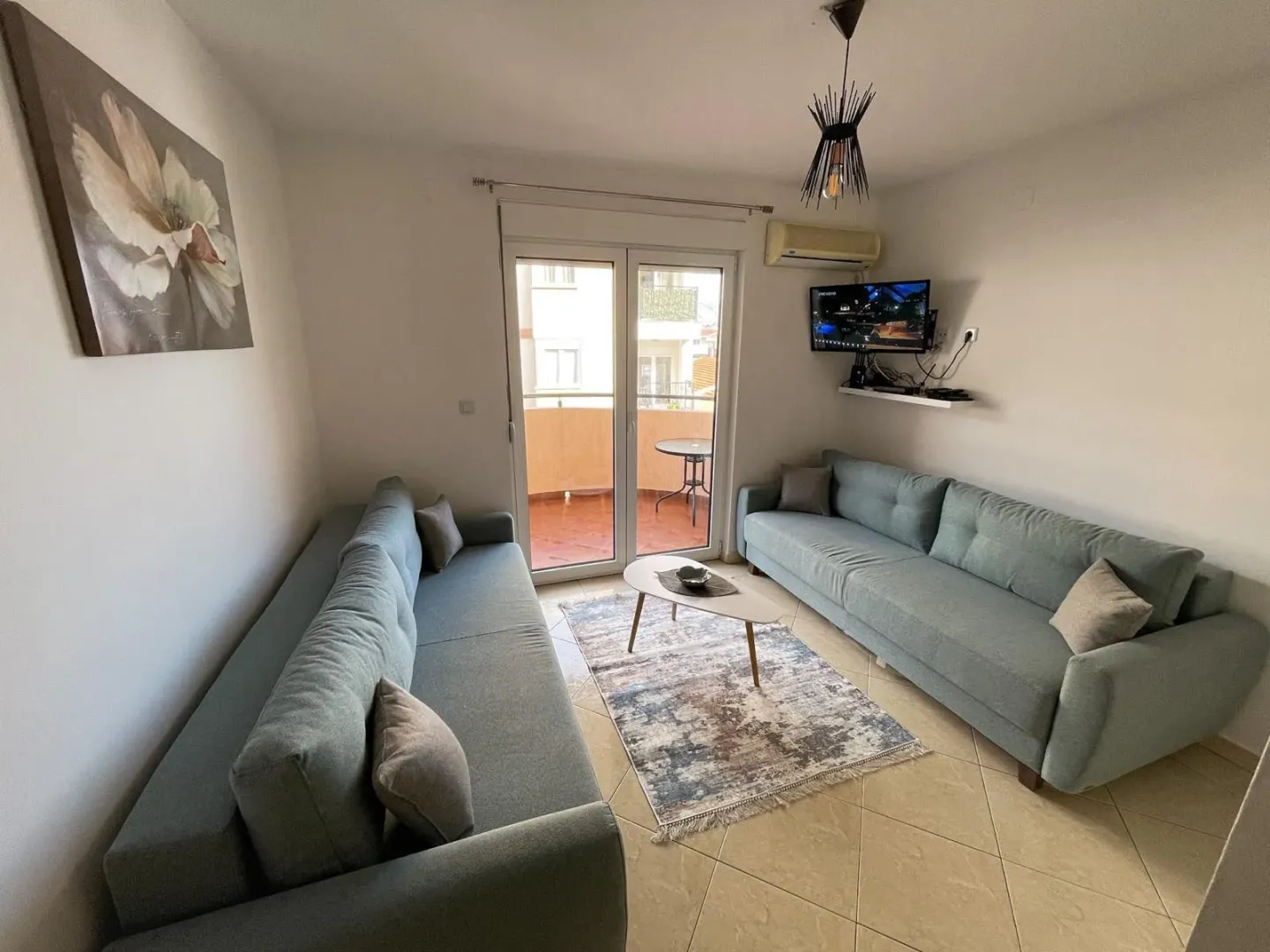 Living room with sofas, a coffee table, and access to the terrace.
