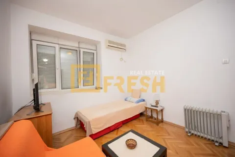 Manja spavaća soba sa krevetom, televizorom, radijatorom i klima uređajem. - image 4