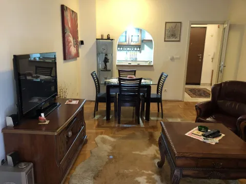 A living room with a dining table, television, and a leather armchair. - image 5