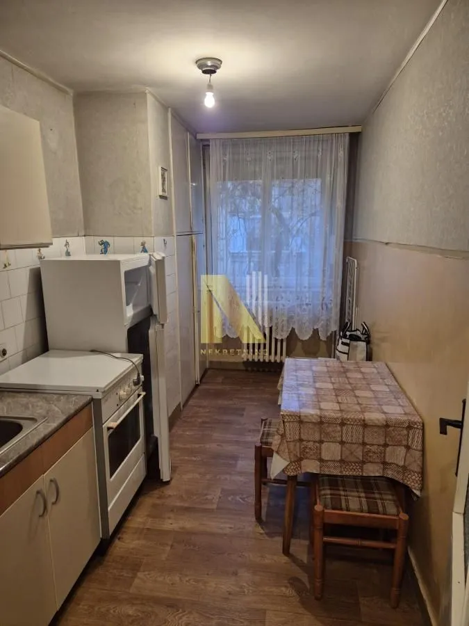 Manja kuhinja sa trpezarijskim stolom i izlazom na terasu.