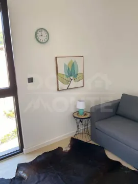 Dio dnevnog boravka sa sivom foteljom, stočićem i ukrasnim detaljima na zidu. - image 2