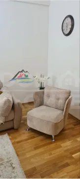 Dio dnevnog boravka sa foteljom i ukrasnim satom na zidu. - image 5