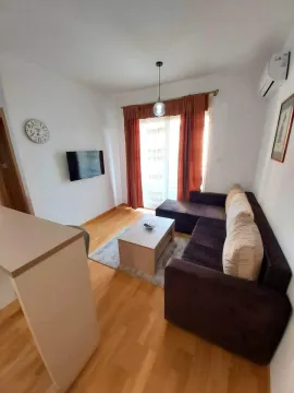 Living room with a sectional sofa and wall-mounted TV. - image 2