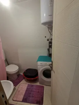 Small bathroom with a washing machine and water heater. - image 8