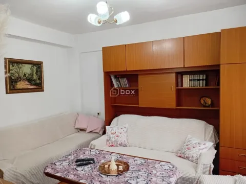 Dnevna soba sa garniturom za sedenje i drvenim ormarima. - image 2