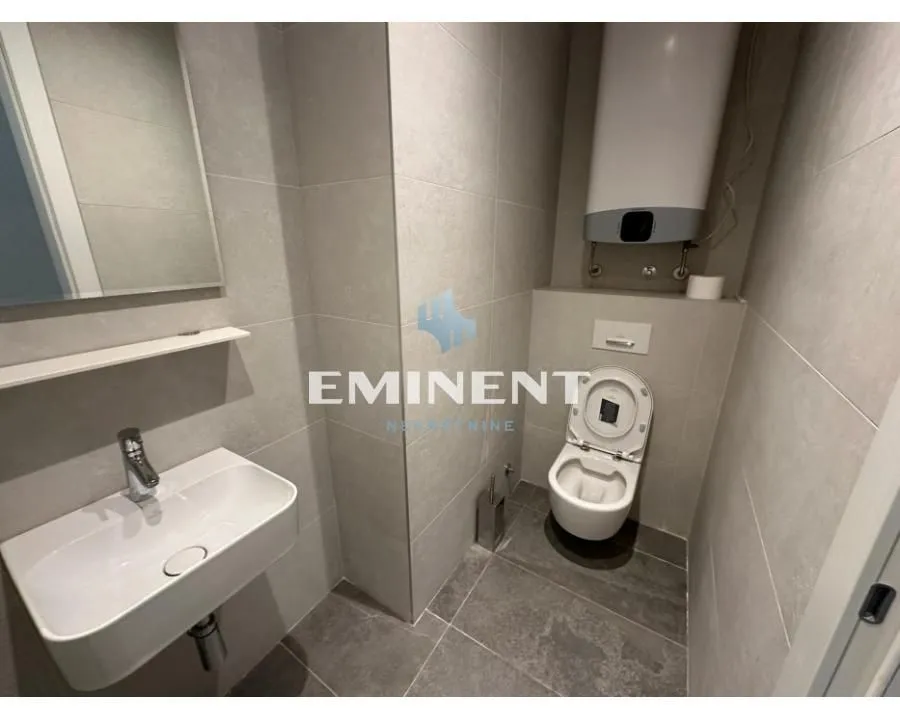 Modern bathroom equipped with a washbasin, toilet, and water heater.
