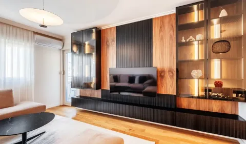 Modern living room with built-in cabinets, television, and wooden wall panels. - image 4