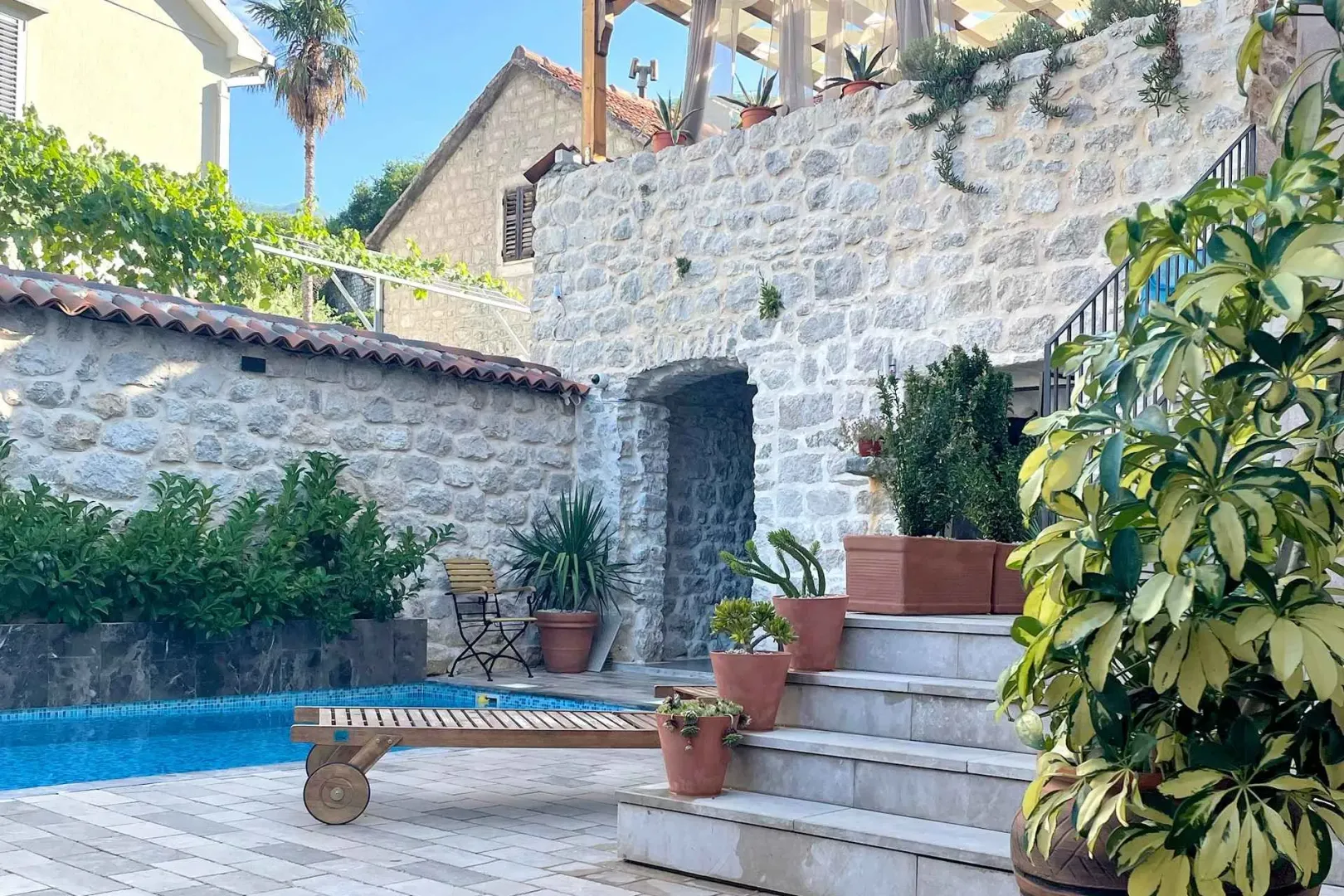 Courtyard with a swimming pool and a stone house.