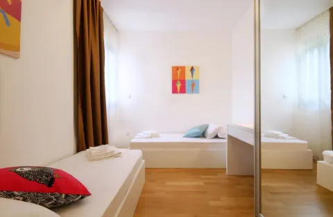 Bright bedroom with two single beds and a mirrored wardrobe. - image 14