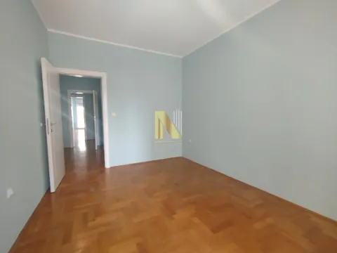Prazna soba sa parketom i otvorenim vratima koja vode u hodnik. - image 4