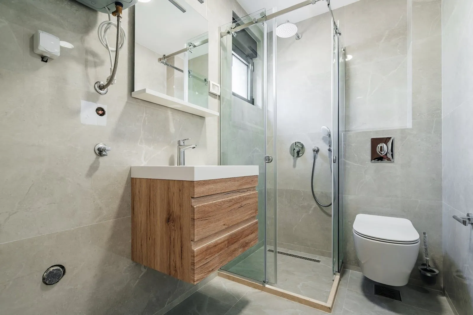 Savremeno opremljeno kupatilo sa tuš kabinom, umivaonikom i wc šoljom.