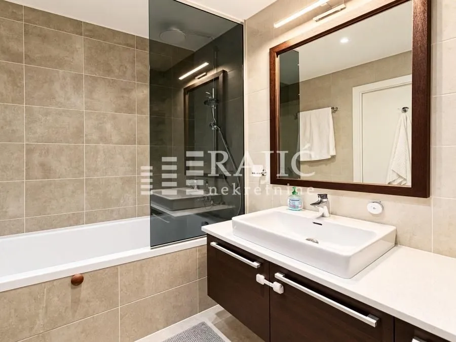 Modernly equipped bathroom with a bathtub and a sink.