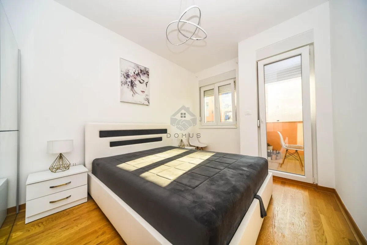 Furnished bedroom with a double bed, bedside table, and access to the terrace.