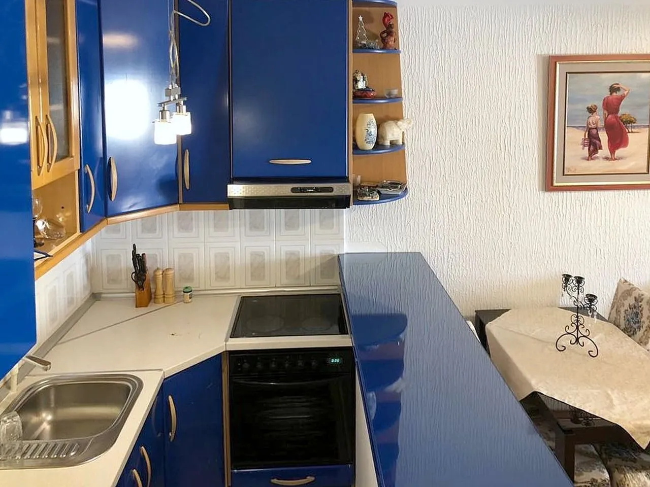 Kitchen equipped with blue cabinetry and a breakfast bar.