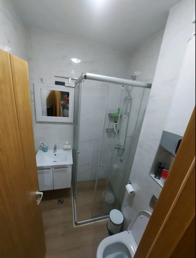 Manje kupatilo sa tuš kabinom, umivaonikom i toaletom.