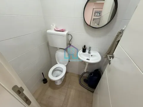 Manje kupatilo sa WC šoljom, umivaonikom i okruglim ogledalom. - image 15