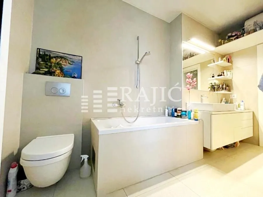 Modern bathroom equipped with a bathtub, toilet, and sink.