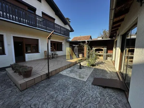 Dvorište kuće sa popločanom terasom, roštiljem i balkonom. - image 2