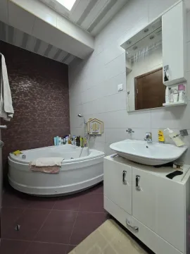 Kupatilo opremljeno ugaonom kadom, umivaonikom i visećim elementom sa ogledalom. - image 10