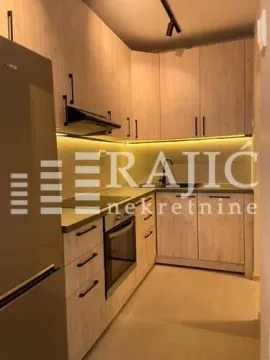 Modern kitchen with light wood cabinets and built-in lighting. - image 10