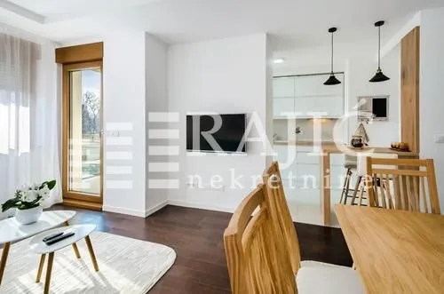 Living room with dining area and kitchen in the background.
