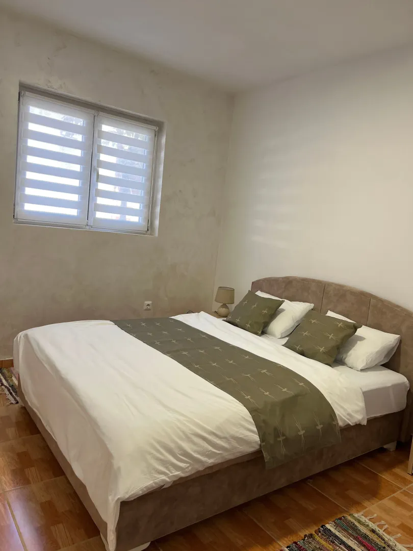 Furnished bedroom with a double bed and a window.