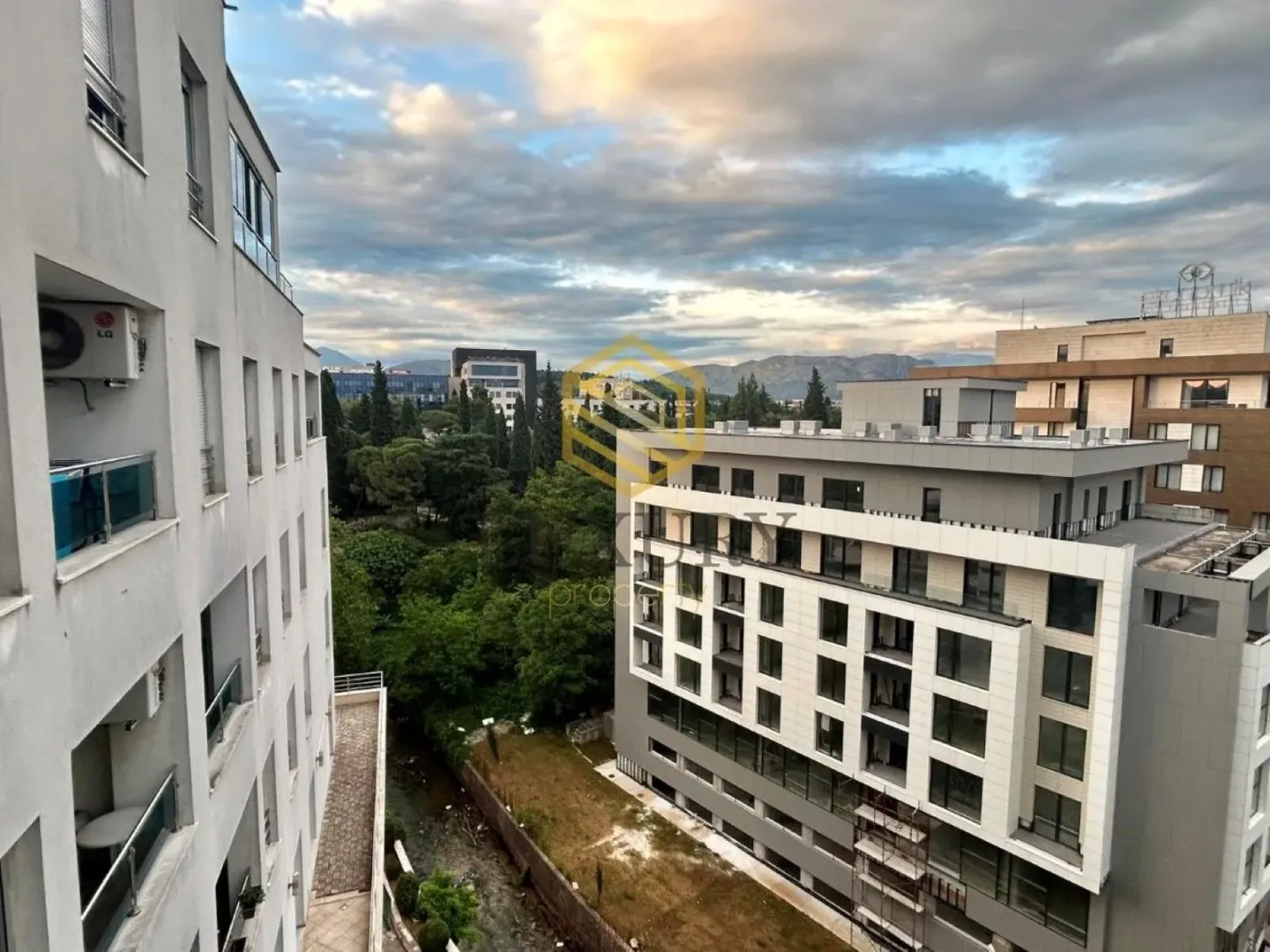 Pogled sa terase na okolne zgrade i gradsko zelenilo.