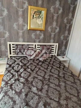 Bračni krevet u spavaćoj sobi sa tapetama na zidu i umetničkom slikom. - image 11