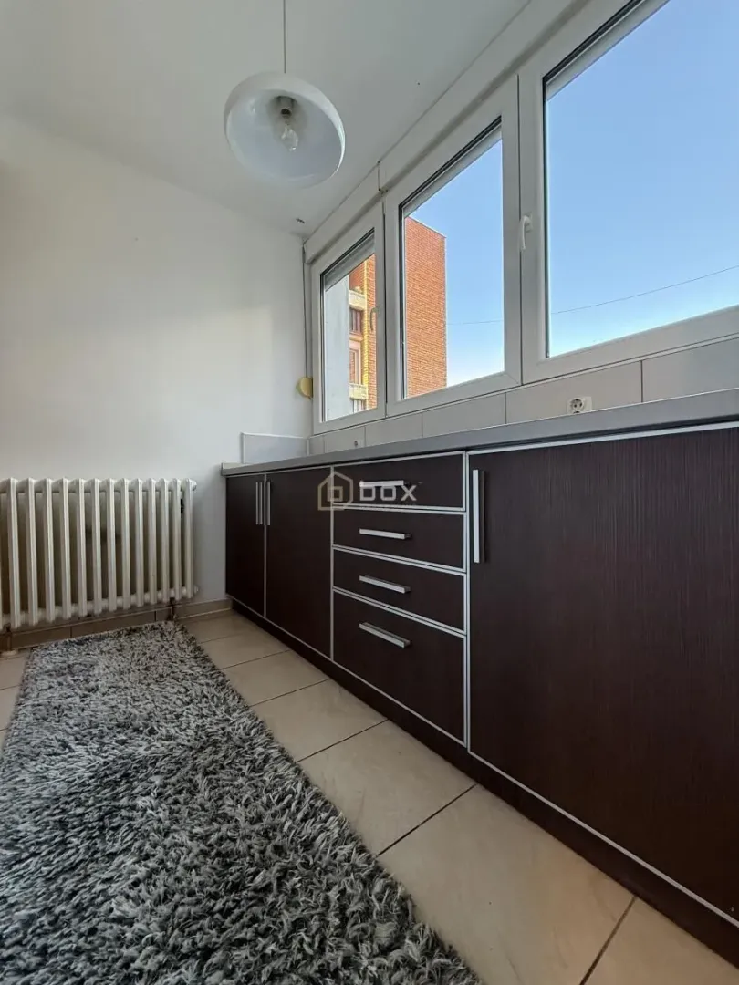 Small kitchen with dark cabinets and a window.